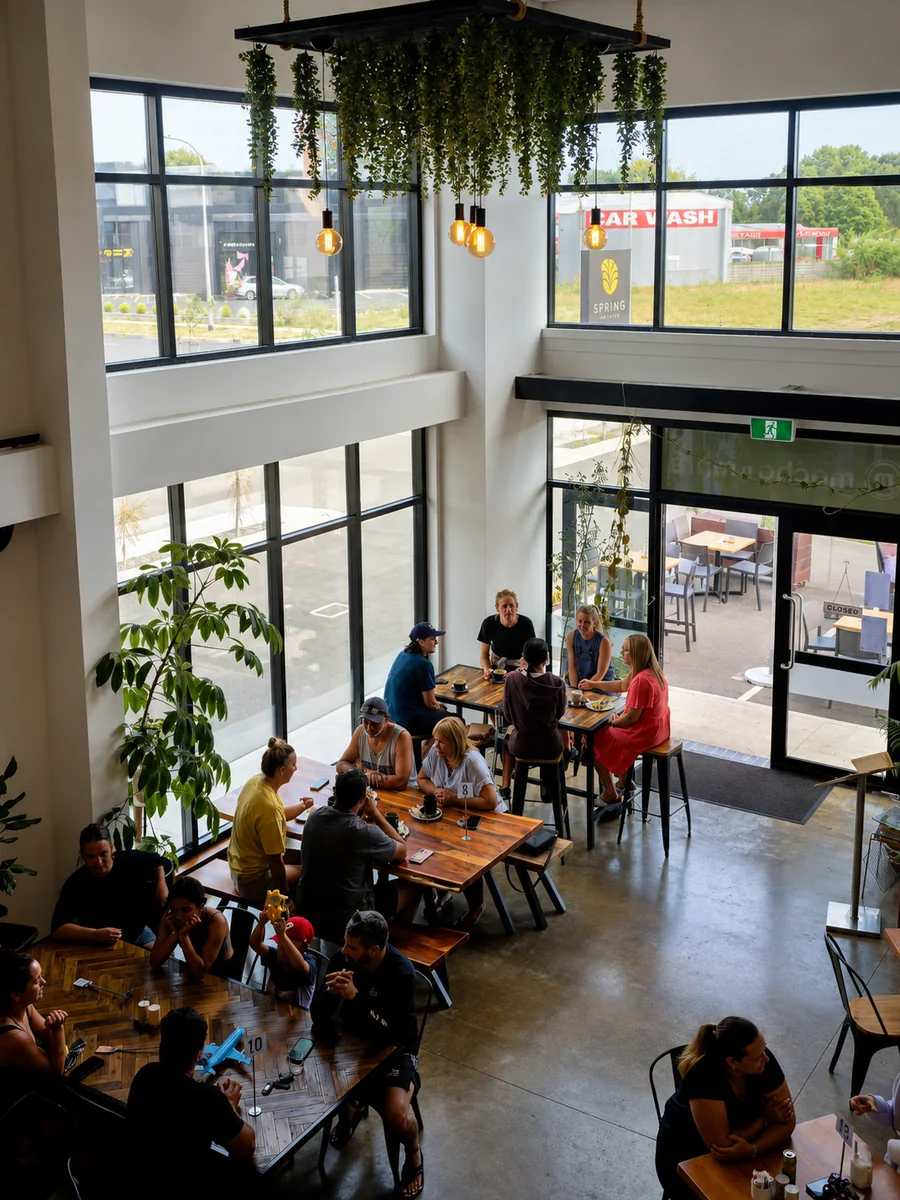 Guests dining beneath hanging plants inside the café